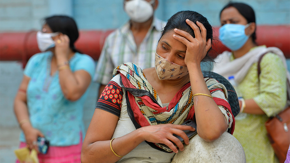 Väntande kvinnor med munskydd utanför ett sjukhus i Kolkata (Calcutta)