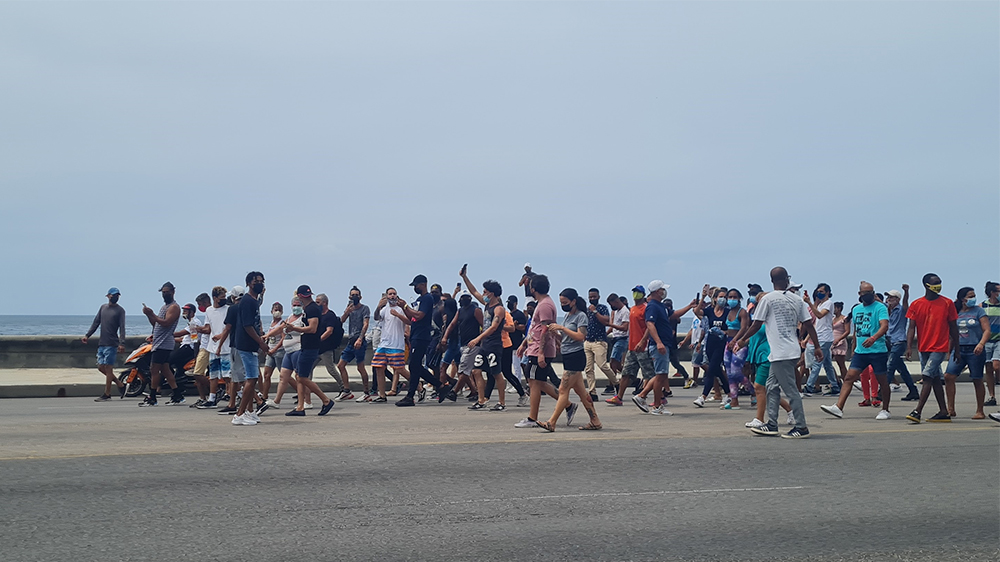 Människor som går i demonstrationståg på Kuba den 11e juli 2021