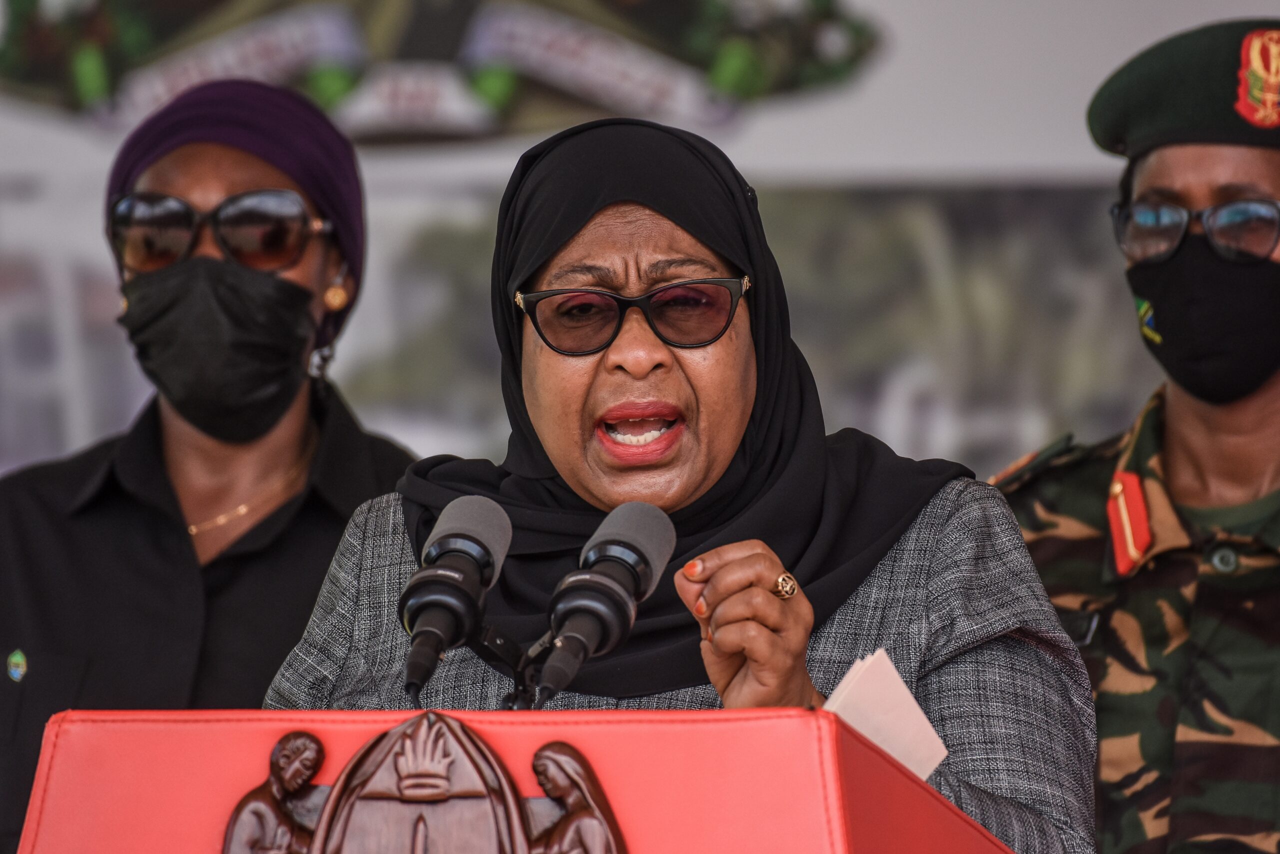 En kvinna med glasögon och hijab talar i en mikrofon.