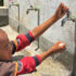 Pojke tvättar händerna under rinnande rent vatten från kran